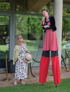 The Principal talking to a circus person on stilts.
