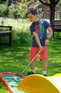 A boy playing crazy golf.