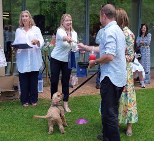 A dog owner being presented with an award.